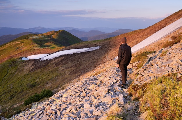 Paysage de printemps avec homme touriste sur un sentier de montagne.