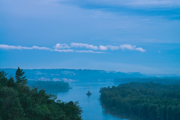 Paysage de rivière magnifique nuit avec rivages verts et navire.