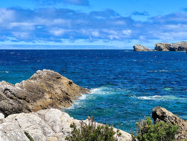 Paysage rocheux de côte de mer avec le ciel bleu clair