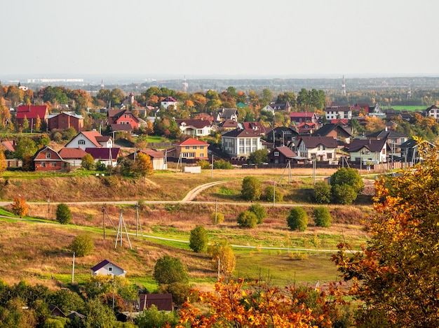 Paysage rural d'automne ensoleillé avec des maisons au loin. Russie.