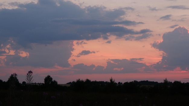 Paysage rural avec champ au coucher du soleil et village en arrière-plan région de vologda