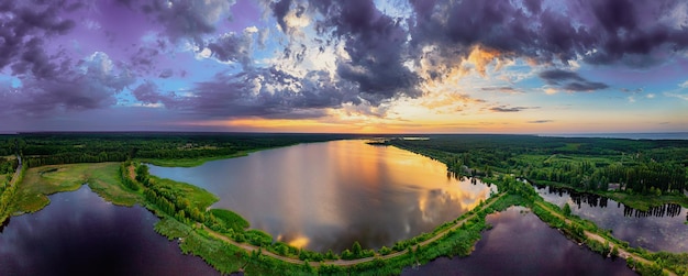 Paysage rural de coucher du soleil d'été avec la rivière et le ciel coloré dramatique vue panoramique aérienne de fond naturel