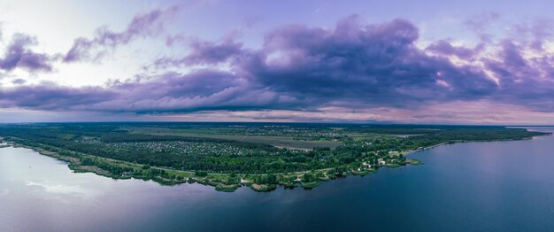 Photo paysage rural de coucher de soleil d'été avec rivière et ciel coloré dramatique, fond naturel, vue panoramique aérienne