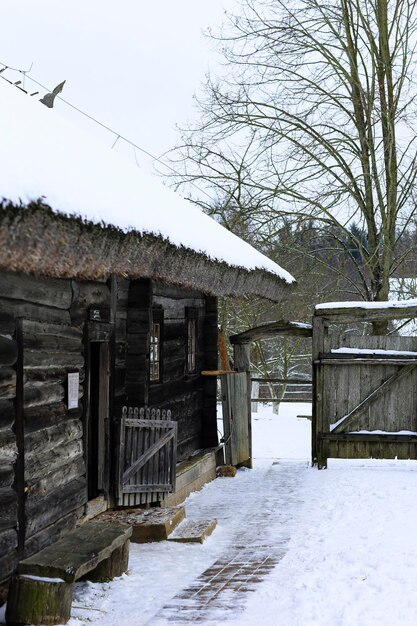 Paysage russe d'hiver Une vieille cabane en bois une maison en rondins avec un toit de chaume Village russe abandonné couvert de neige Maison en rondins avec grange