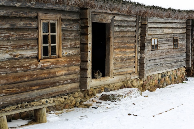 Paysage russe d'hiver Une vieille cabane en bois une maison en rondins avec un toit de chaume Village russe abandonné couvert de neige Maison en rondins avec grange