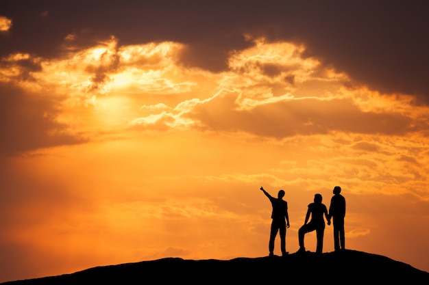 Paysage avec la silhouette d'un peuple heureux sur la montagne au coucher du soleil