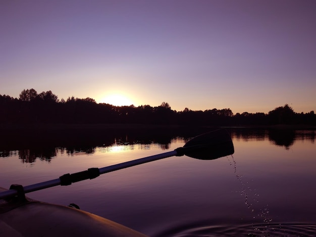 Paysage de soirée d'été avec surface du lac et fragment de pagaie de bateau gonflable. Lettonie, Europe de l'Est.