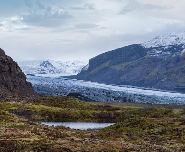 Photo paysage de la toundra d'automne en islande près du glacier haoldukvisl islande glacier glisse de la langue de la calotte glaciaire vatnajokull ou du glacier vatna près du volcan subglaciaire esjufjoll non loin de la route périphérique d'islande