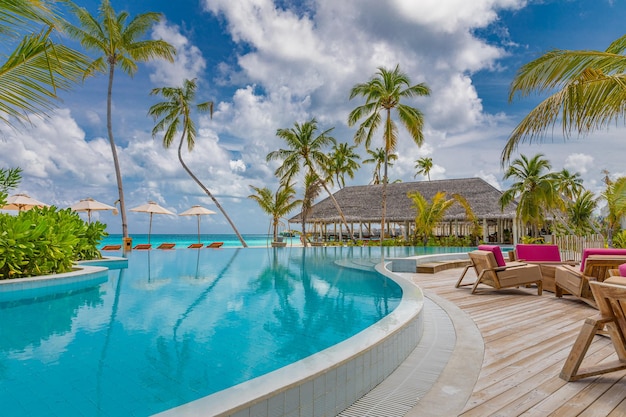 Paysage de tourisme de plein air. Station balnéaire de luxe, piscine à débordement, chaises de plage, lits, palmiers