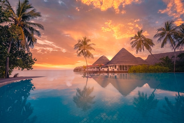 Paysage touristique au coucher du soleil. Station balnéaire luxueuse avec reflet de la piscine à débordement Palm Sky