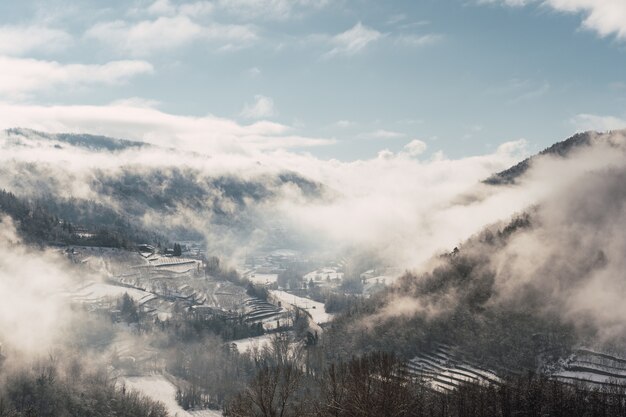 Photo paysage tout blanc couvert de neige et de brouillard dans le nord de l'italie.