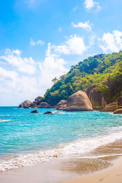 Paysage tropical vertical Mer avec un rivage rocheux et une montagne par une journée ensoleillée sur une île tropicale Voyage et tourisme