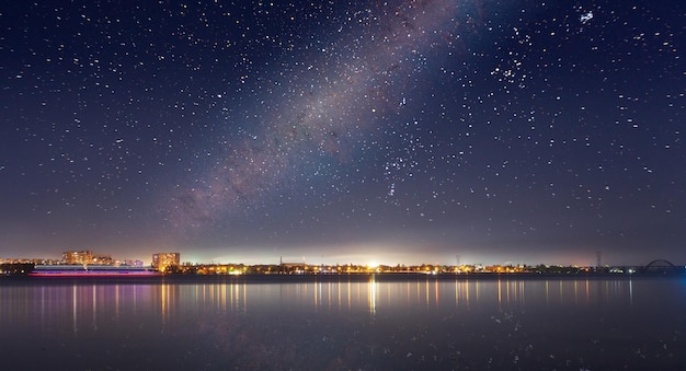 Paysage urbain abstrait avec des immeubles de grande hauteur modernes, des gratte-ciel et des lumières de la ville se reflétant dans la surface de l'eau miroir d'une rivière ou d'un lac calme dans la nuit noire Sans personne