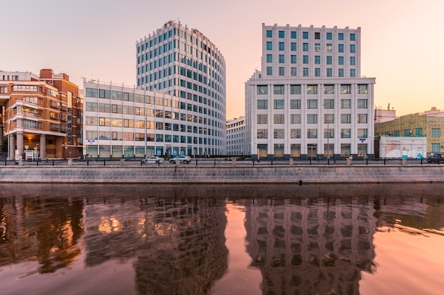 Paysage urbain au coucher du soleil avec des immeubles de bureaux modernes au bord d'une rivière