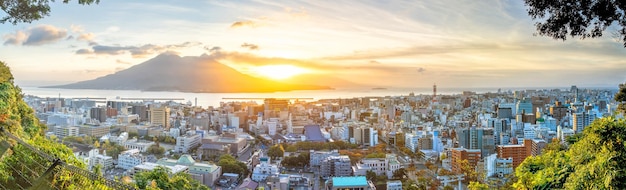 Le paysage urbain du centre-ville de Kagoshima avec le volcan Sakurajima à Kyushu au lever du soleil.