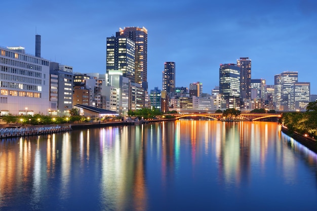 Photo le paysage urbain d'osaka au japon sur la rivière au crépuscule