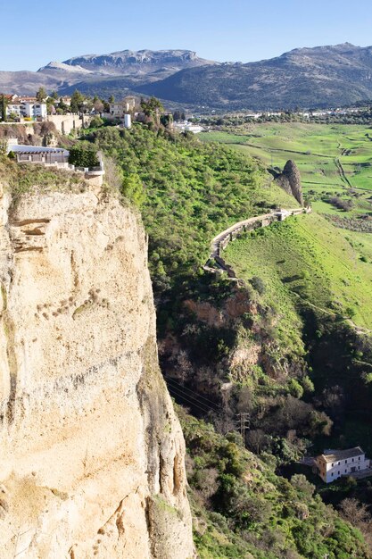 Paysage de vieux bâtiments et jardins sur les falaises d'une gorge avec un fond de champ avec verger