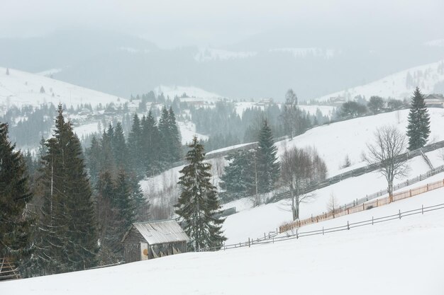 Paysage de village de montagne d'hiver tôt le matin