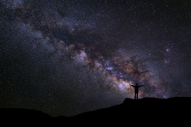 Paysage avec voie lactée Ciel nocturne avec étoile et silhouette de gens heureux debout sur la montagne