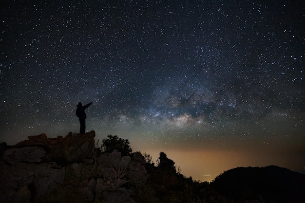 Paysage avec voie lactée avec étoiles et silhouette de gens heureux debout sur Doi Luang Chiang Dao