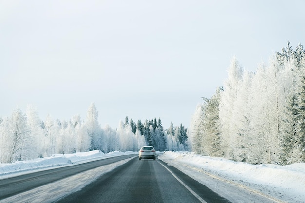 Paysage avec une voiture sur la route à l'hiver enneigé Laponie, Rovaniemi, Finlande