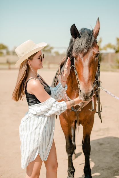 Paysanne dans un ranch avec un cheval brun