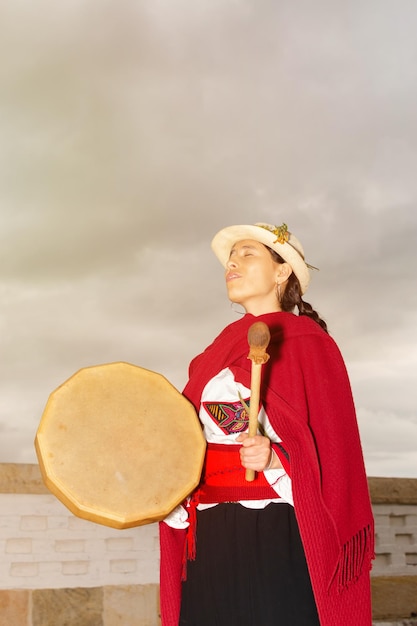 Paysanne latine avec costume typique jouant du tambour en chantant