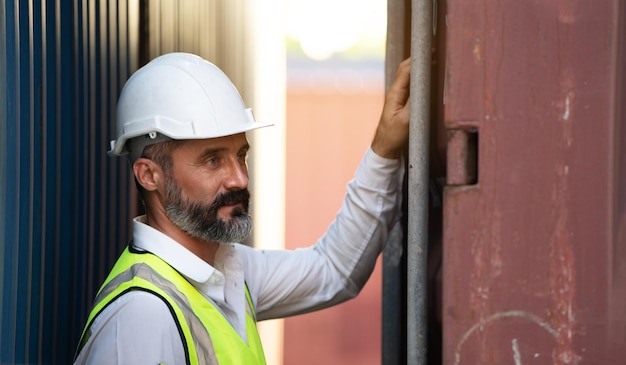 PDG ou directeur en casque blanc vérifiant et contrôlant le chargement de la boîte de conteneurs dans le gestionnaire d'entrepôt