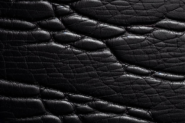 Une peau d'alligator texturée en cuir noir avec un fond noir.