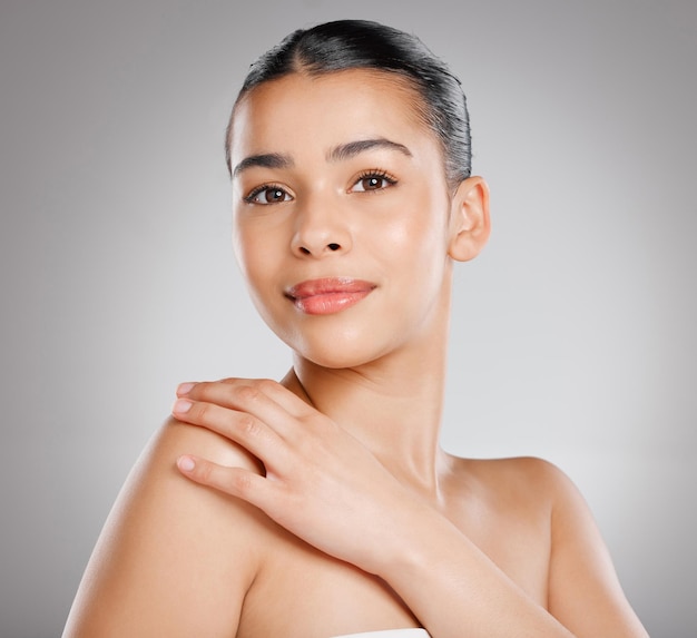 Une peau éclatante vous donne un coup de pouce supplémentaire en matière de beauté Photo en studio d'une jolie jeune femme posant sur un fond gris