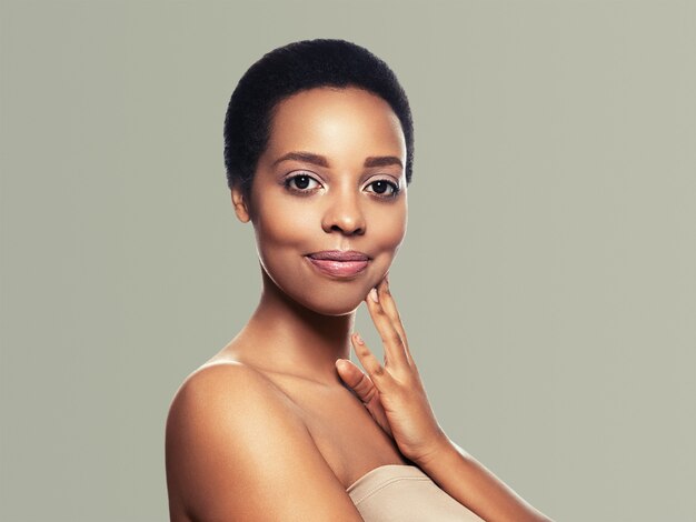 Peau noire beauté femme cheveux sains peau proche beau modèle afro-américain avec les mains. Sur gris.