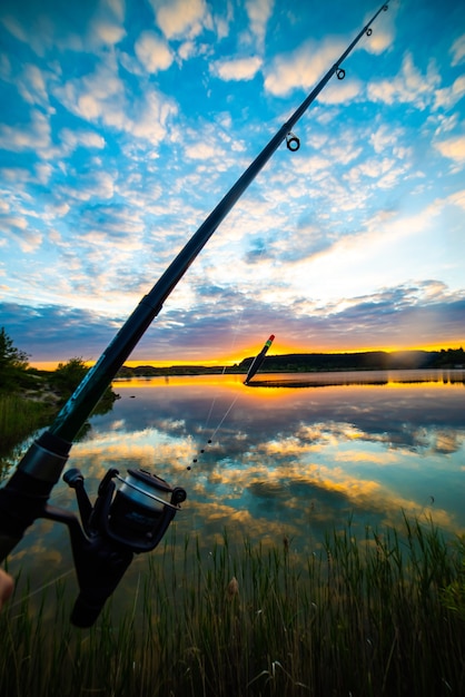 Pêche sur le lac au coucher du soleil d'été