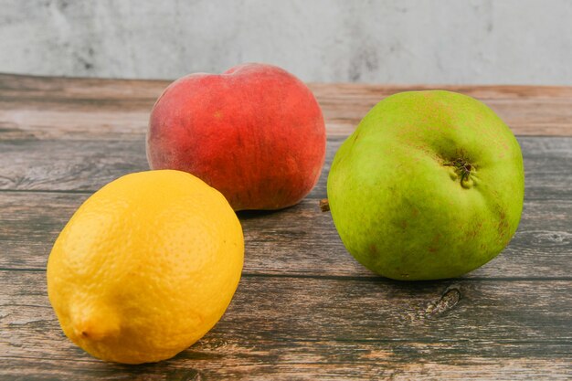 Pêche, poire, citron sur un fond en bois. Blocs de bois avec les mots vitamine C, fruits frais en arrière-plan, alimentation saine ou concept de régime alimentaire. Vue d'en-haut. Lieu d'écriture.