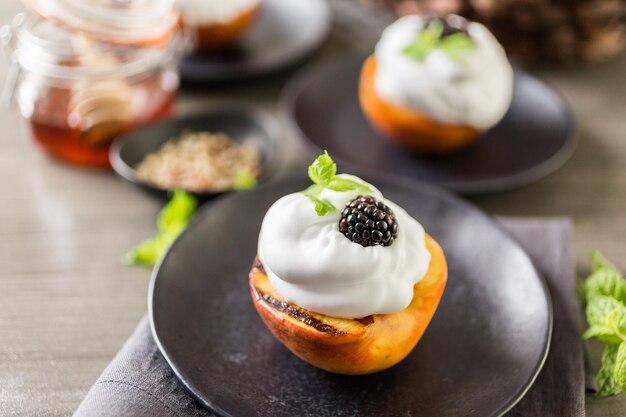 Pêches biologiques grillées à la crème fouettée et garnies de menthe fraîche.