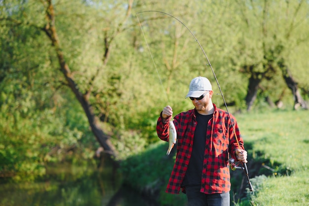 Pêcheur au bord de la rivière avec une prise de poisson