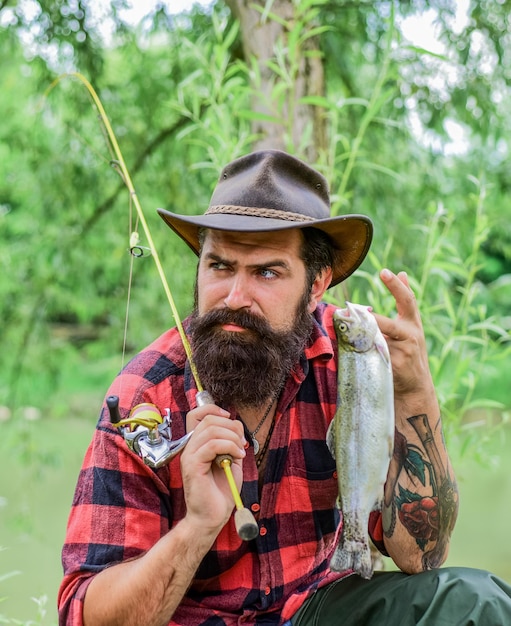 Pêcheur en camping Week-end d'été de pêche réussi pêcheur expérimenté dans l'activité sportive forestière et passe-temps homme avec de grandes prises de poisson homme mûr se détendre après la pêche Souhaitant que je pêchais