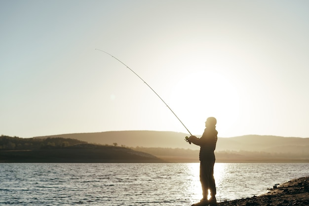 Pêcheur avec canne à pêche sur le lac