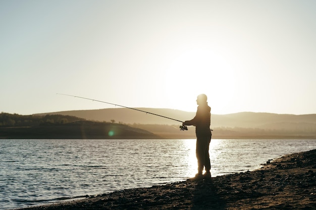 Pêcheur avec canne à pêche sur le lac