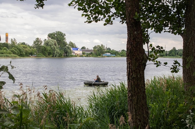 Pêcheur dans une barque au milieu d'une rivière