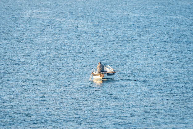 Pêcheur dans un bateau de pêche tôt le matin. Mer Méditerranée. Italie.