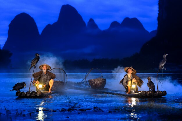 Pêcheur de Guilin, rivière Li et montagnes karstiques pendant l'heure bleue de l'aube, Guangxi Chine