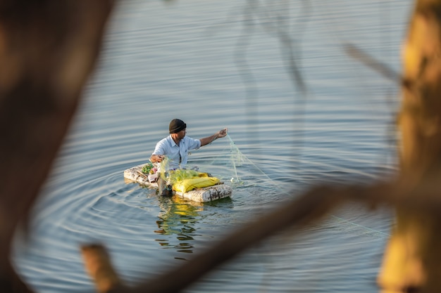 Pêcheur indien pêche en bateau fait main