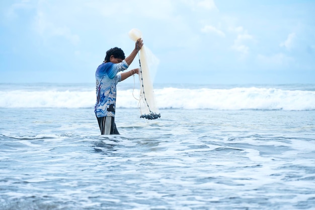 Pêcheur à l'intérieur de la mer avec son filet