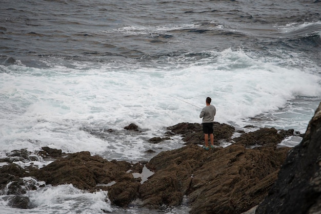 Pêcheur jetant la tige des rochers