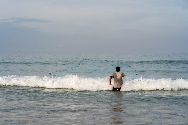 Le pêcheur a jeté un filet sur la plage.