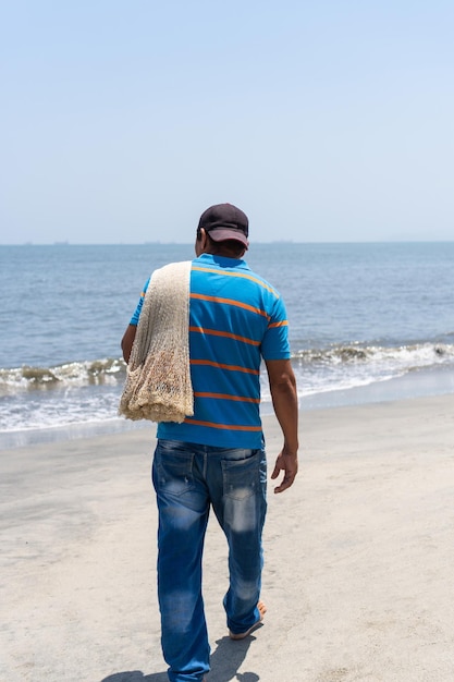 Pêcheur marchant avec un filet de pêche se préparant à aller à la mer