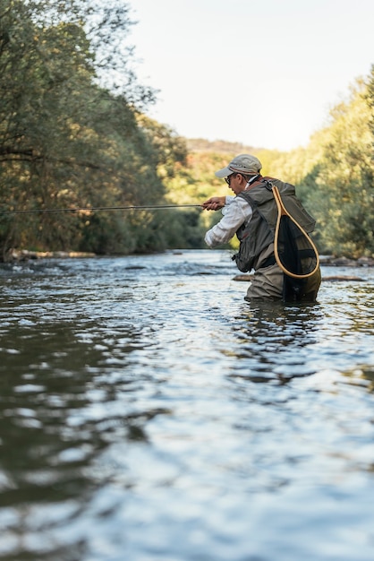 Pêcheur à la mouche utilisant une canne à pêche à la mouche dans une belle rivière