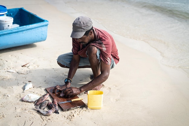 Pêcheur noir candide sur la côte près de l'océan