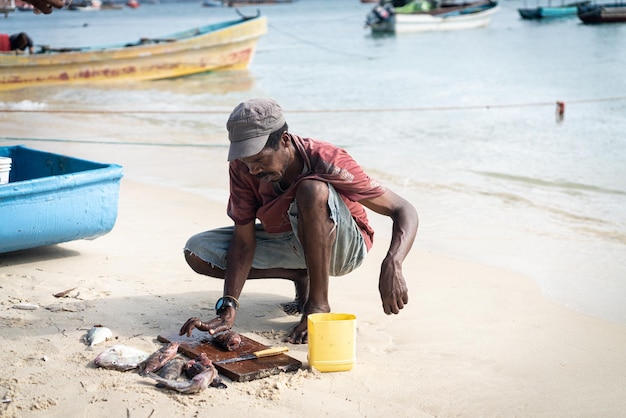 Pêcheur noir candide sur la côte près de l'océan