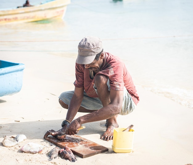 Pêcheur noir candide sur la côte près de l'océan